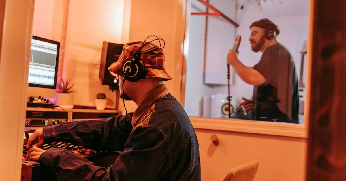 Producteur et chanteur dans un studio de musique professionnel, collaborant lors d'une session d'enregistrement.